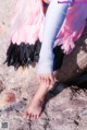 A little girl with a cast on her leg sitting on a rock.