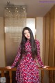 A woman in a red and blue dress standing on a staircase.