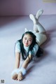 A young woman laying on the floor wearing bunny ears.