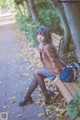 A woman sitting on a bench in a park.