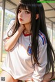 A girl with long black hair wearing a white shirt.